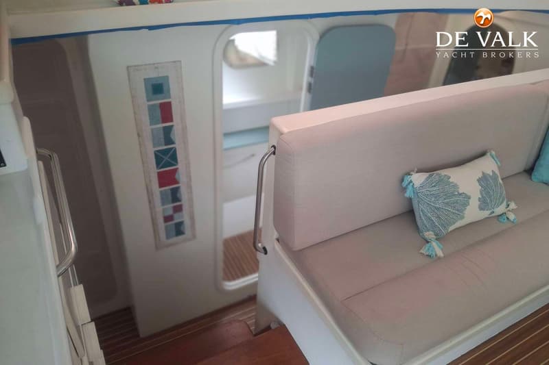 Een interieur van een boot met een bankje met kussens, een trap naar beneden en een doorgang. — Punch 1500 LC