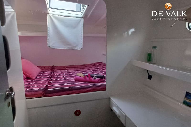 Een kajuit met een roze gestreept beddengoed, een roze kussen en een open dakluik met een wit rolgordijn. — Punch 1500 LC