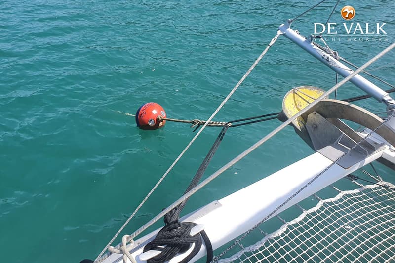 Een rode boei met Thaise tekst drijft in turquoise water, verbonden met een boot via lijnen en kabels. — Punch 1500 LC