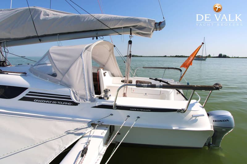 Een witte zeilboot met een grijze buiskap en een Honda buitenboordmotor ligt in het water. — Dragonfly DF 28 Touring