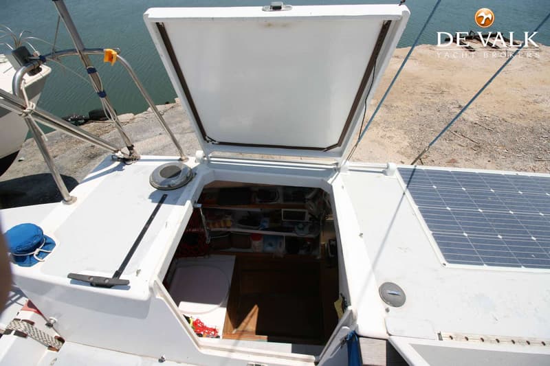 Een open luik op een wit dek met een zonnepaneel en een glimp van de kajuit. — Wharram Tiki 30