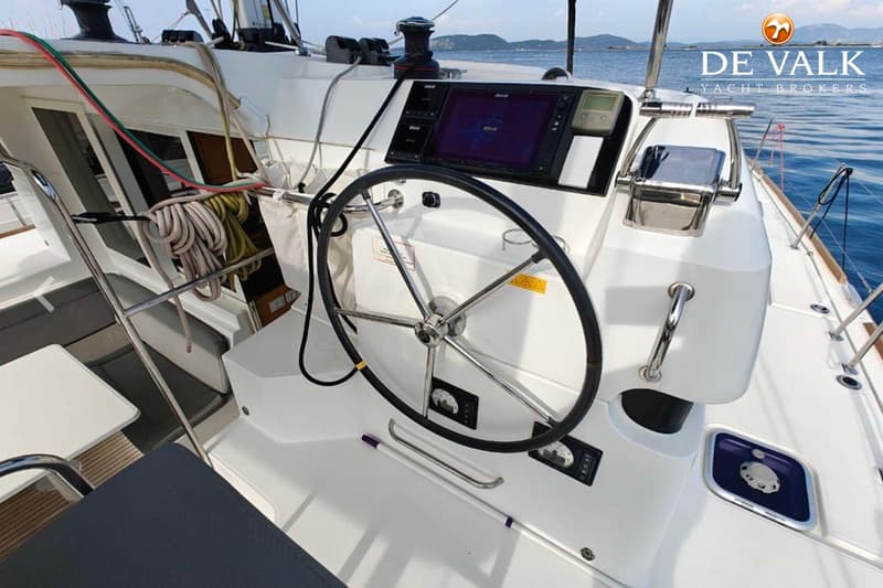 Een stuurwiel, navigatiescherm en diverse meters zijn zichtbaar in de kuip van een boot. — Lagoon 39