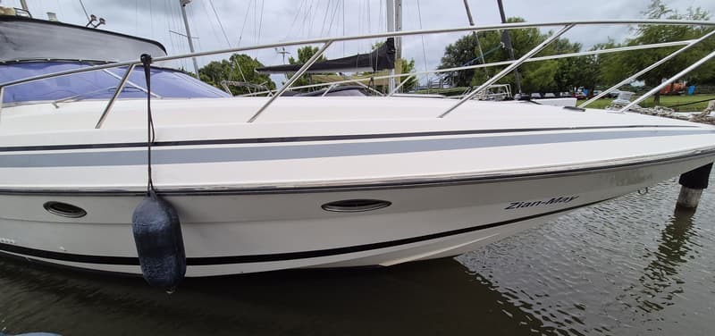 Een witte boot met blauwe ramen en een zwarte stootwil hangt aan de zijkant. — Sunseeker 38 Martinique