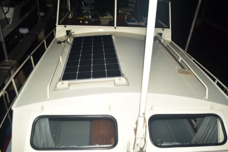 Een wit dek van een boot met een zonnepaneel, twee ramen en een mast. — Doerak 850 AK