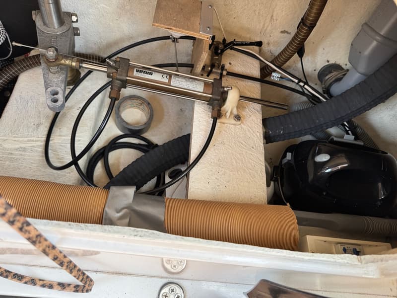 Een Vetus hydraulische cilinder, model MTC30, is zichtbaar tussen diverse slangen, kabels en een rol tape.