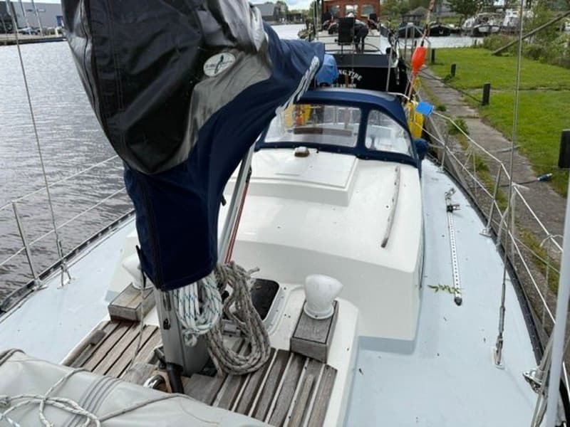Een bovenaanzicht van het dek van een zeilboot met een mast, zeilhuik, touwen en een kajuitopbouw. — Victoire 34 S-spant