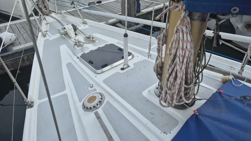 Een bovenaanzicht van het dek van een zeilboot met een ankerlier, luik, mast en touwen. — Contest 36 Ketch