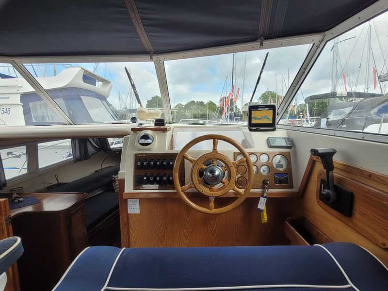 De foto toont het interieur van een boot met een houten stuurwiel, navig — Agder 840 OK