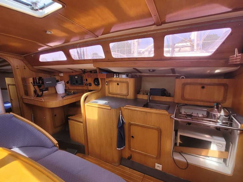 De foto toont het interieur van een boot met houten afwerking, een kombuis en een navigatiehoek. — Feeling 346