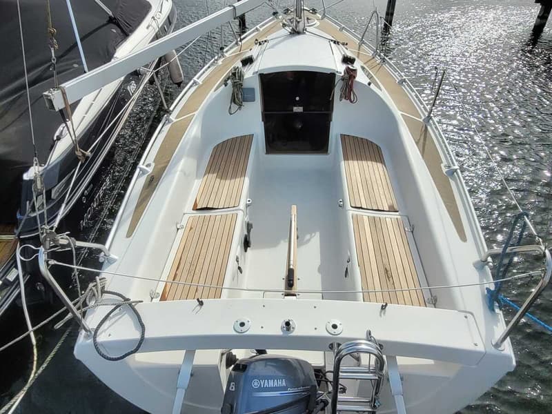 Een witte zeilboot met houten dekdelen en een Yamaha buitenboordmotor ligt in het water naast een andere boot. — Etap 21i