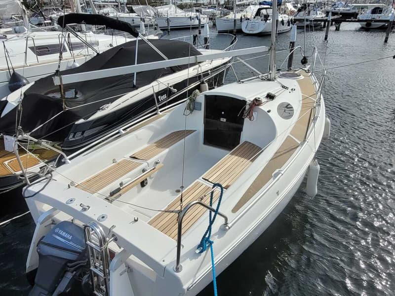 Een witte zeilboot met houten dek en een Yamaha buitenboordmotor ligt aangemeerd in een haven. — Etap 21i