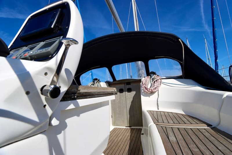 De foto toont een deel van de kuip van een zeilboot met een stuurstand, navigatie-instrumenten en een buiskap. — Bavaria 31