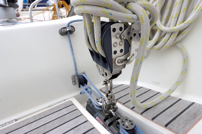 Een detailfoto van een boot met een blok, touwen en een houten rooster op de vloer. — Beneteau First 41S5