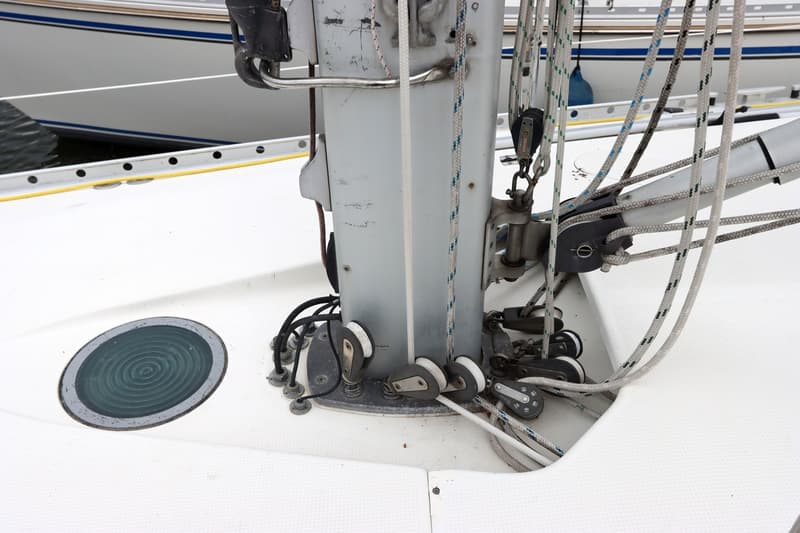 Een detailfoto van het dek van een zeilboot met de mastvoet, diverse lijnen, blokken en een luik. — Beneteau First 41S5