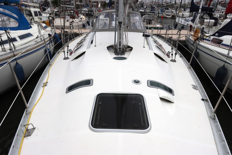 Een witte zeilboot ligt in een haven, met andere boten op de achtergrond. — Beneteau First 41S5