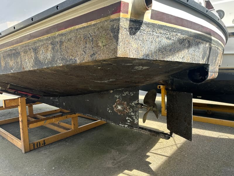 De onderkant van een boot met een schroef en roer, staand op een gele bok met nummer 104. — Succes Ultra 500