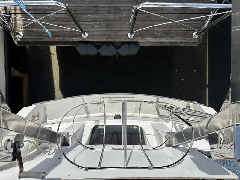 Een bovenaanzicht van de achtersteven van een witte boot met reling, liggend aan een houten steiger. — Succes Ultra 500