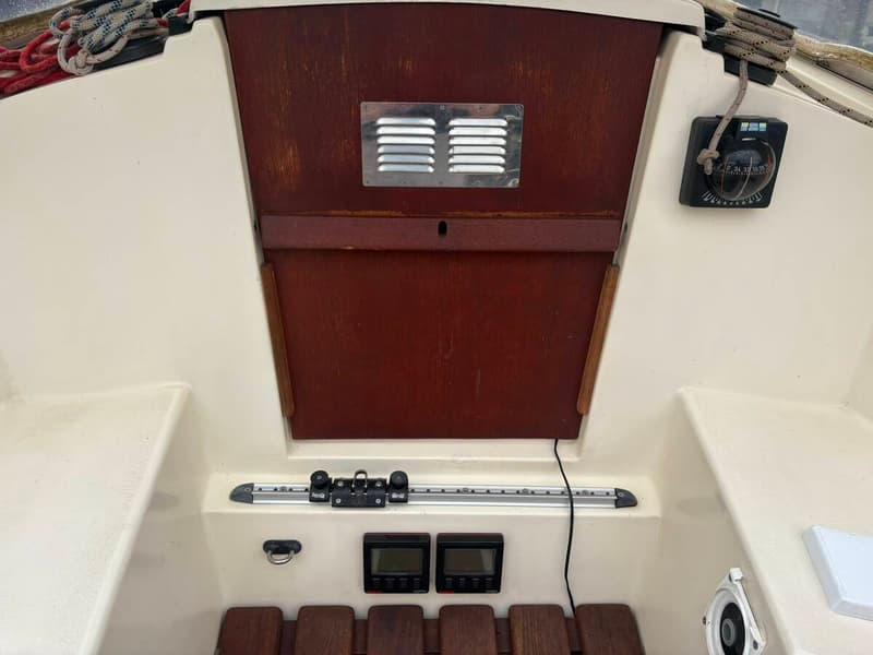 De foto toont het interieur van een boot met een kombuis, zithoek en een open dakluik. — Compromis 777