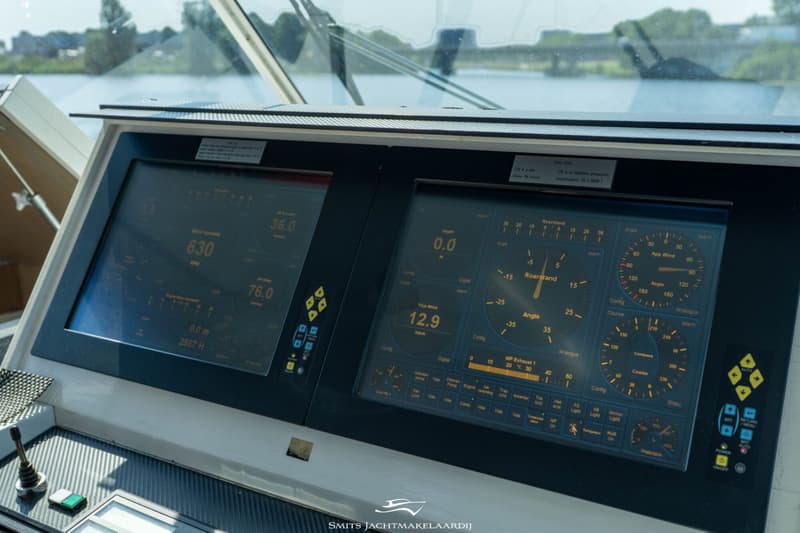 Een close-up van een scheepsdashboard met twee grote digitale schermen die diverse bootinformatie weergeven.