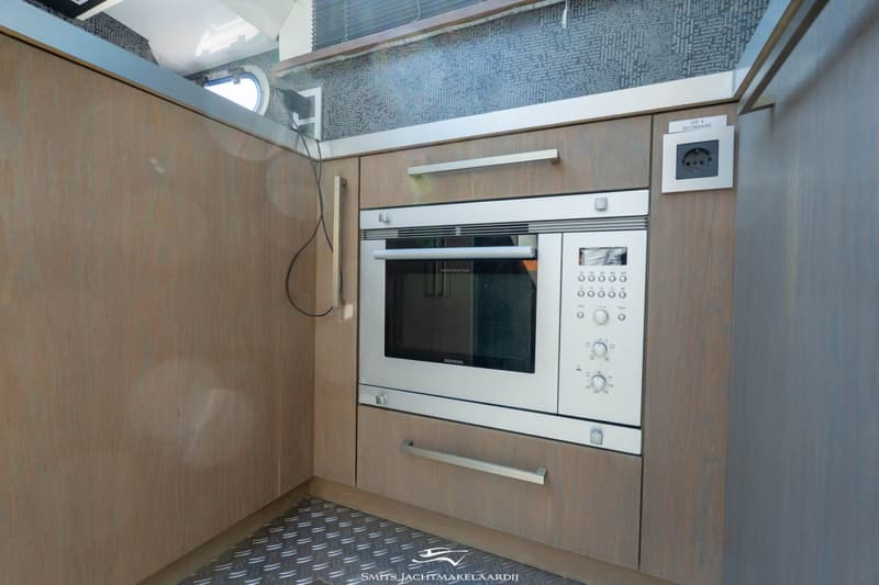 Een ingebouwde Siemens magnetron met daarboven een 220 V stopcontact en daaronder een lade.