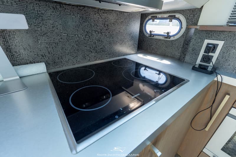 Een Siemens kookplaat met vier pitten is ingebouwd in een lichtgrijze aanrecht in een bootkeuken.