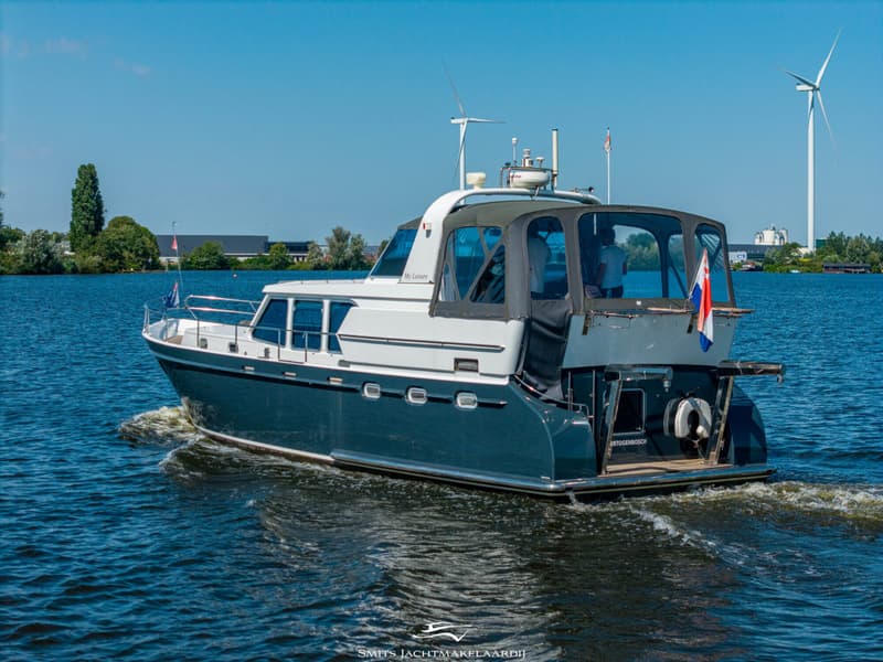 Een blauw-witte motorboot met de naam "My Leisure" vaart op een zonnige dag over het water. — Bekebrede Bekebrede Myco 45 SL