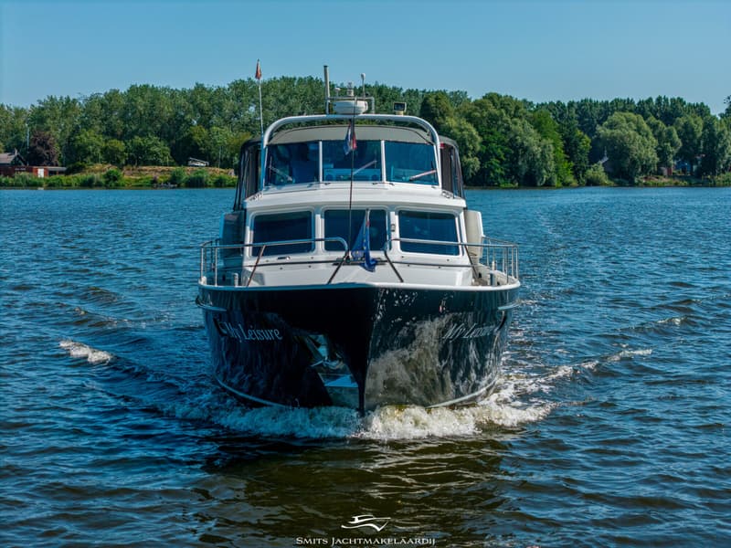 Een donkerblauwe motorboot met witte opbouw vaart over water, met bomen op de achtergrond. — Bekebrede Bekebrede Myco 45 SL