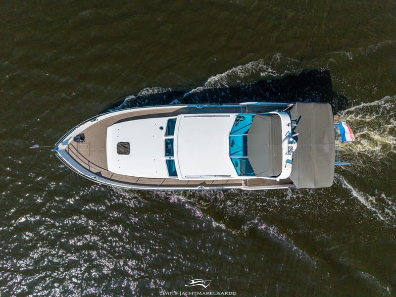 Een witte motorboot met een bruin dek en een grijs afdekzeil vaart op het water. — Bekebrede Bekebrede Myco 45 SL