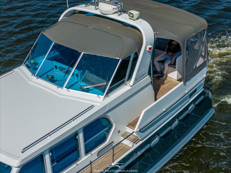 Een witte motorboot met blauw getinte ramen en een grijze kap vaart over het water. — Bekebrede Bekebrede Myco 45 SL