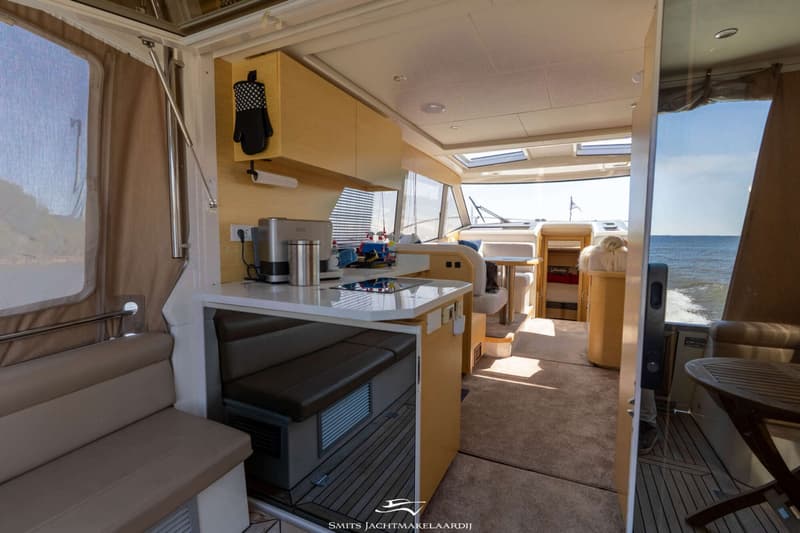 De foto toont het interieur van een boot met een kombuis, zithoeken en uitzicht op water. — Greenline Greenline 39