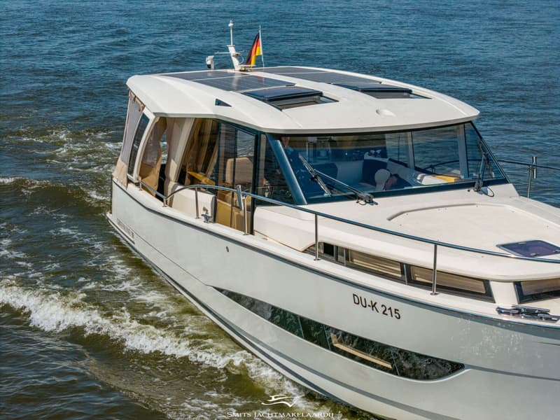 Een witte motorboot met een Duitse vlag en zonnepanelen op het dak vaart op een zonnige dag. — Greenline Greenline 39