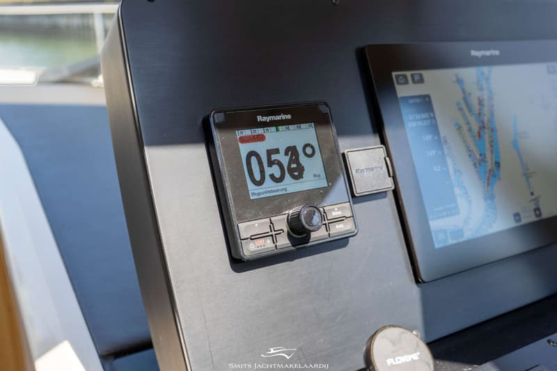 Een Raymarine display toont "054°" en "Wegpunktsteuerung", naast een groter navigatiescherm met een kaart.