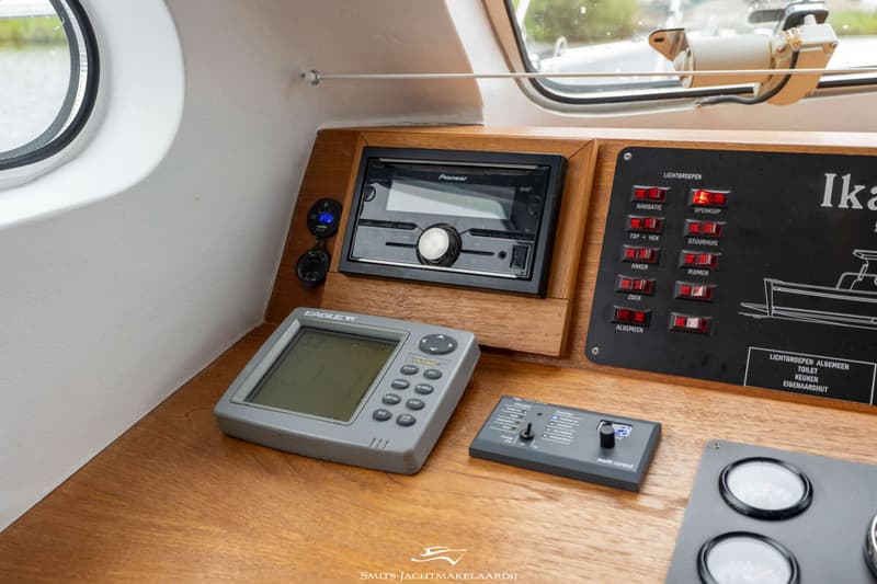 Een dashboard met een Pioneer radio, een Eagle dieptemeter, een schakelpaneel en een Victron Energy multi control.