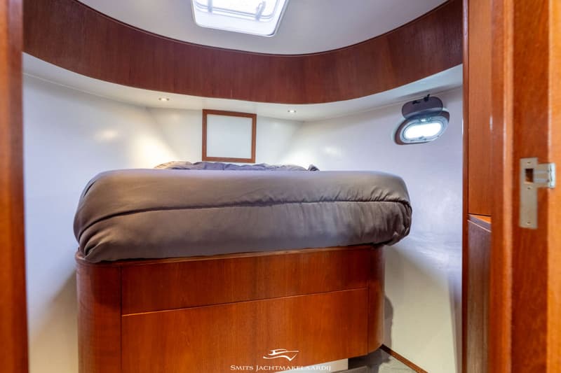 Een kajuit met een bed, houten meubilair, een dakraam en een patrijspoort. — Van Vossen Van Vossen Patrouille 10.50 OK