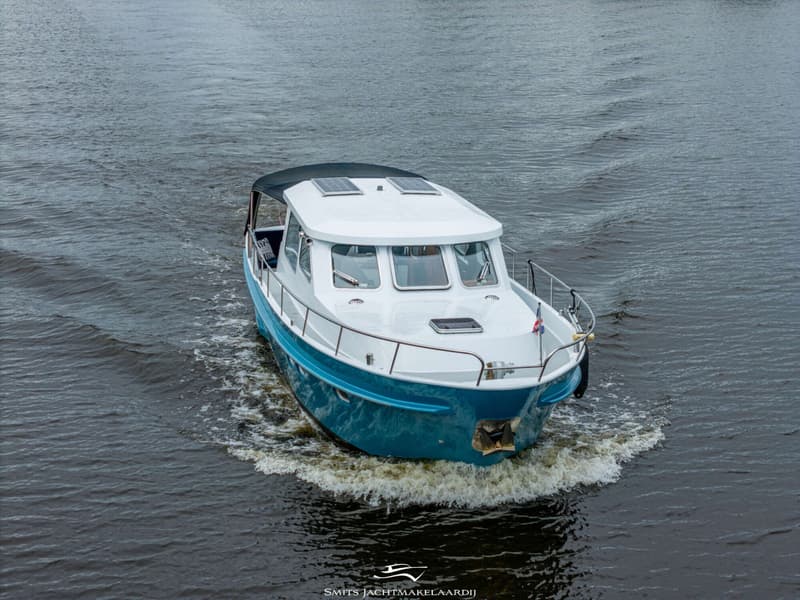 Een blauw-witte motorboot vaart op het water en creëert een kielzog. — Van Vossen Van Vossen Patrouille 10.50 OK