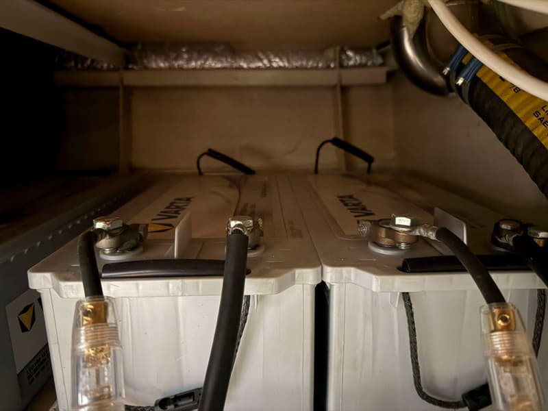 Twee Varta accu's zijn zichtbaar, verbonden met kabels, in een afgesloten ruimte.