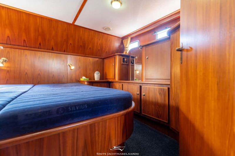 Een kajuit met twee bedden, houten wanden en kasten, en een donkerblauw tapijt. — Babro yachting Babro Classic 13.40 AK