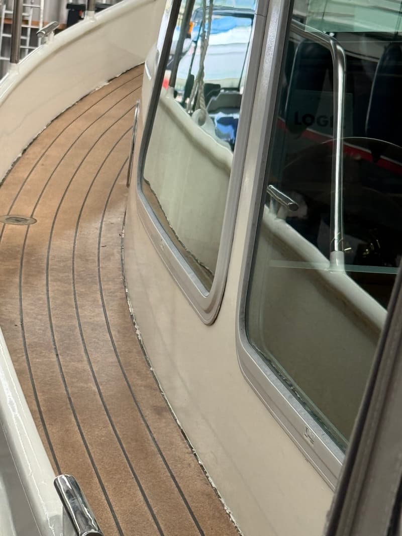 Een detailfoto van het dek van een boot met een houten vloer en een raam van de kajuit. — Barkas Barkas 8.30 OK