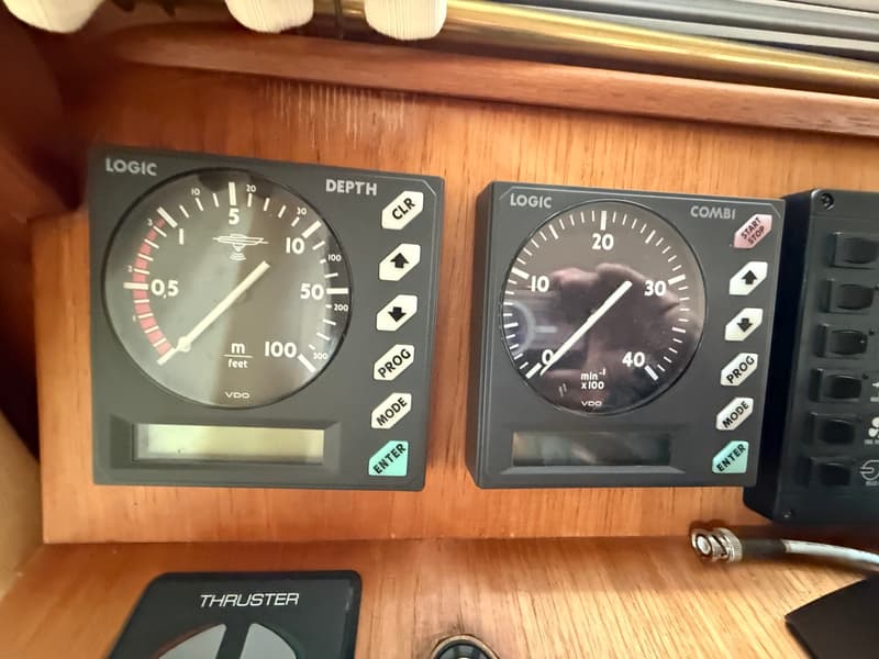 Twee zwarte VDO Logic meters, een dieptemeter en een combi-meter, zijn gemonteerd op een houten paneel.