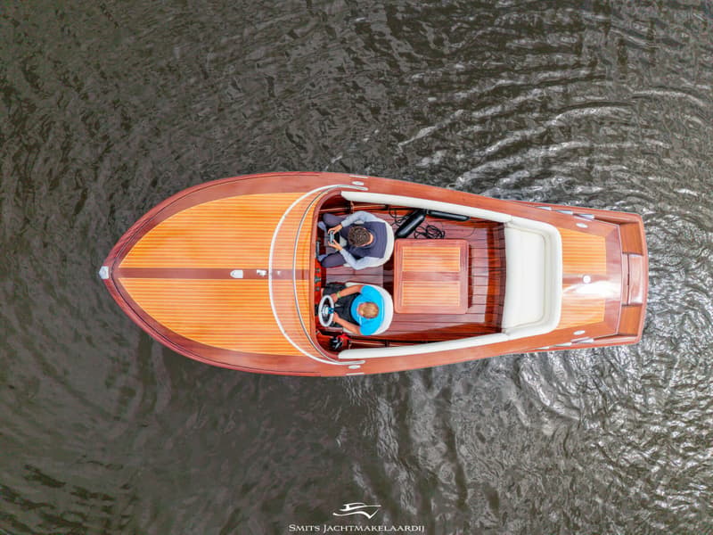 Een houten boot met twee personen aan boord vaart op het water, gezien van bovenaf. — Divank Divank Uscire 635
