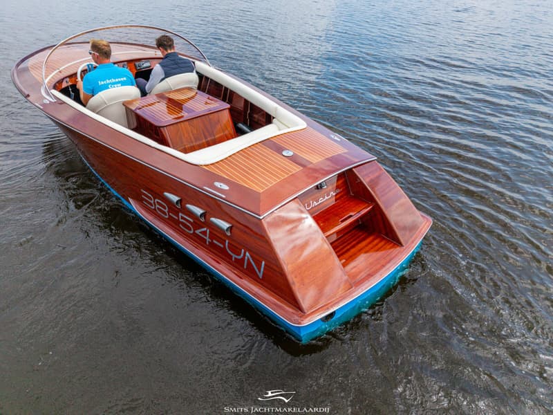 Een houten motorboot met twee personen aan boord vaart op het water. — Divank Divank Uscire 635