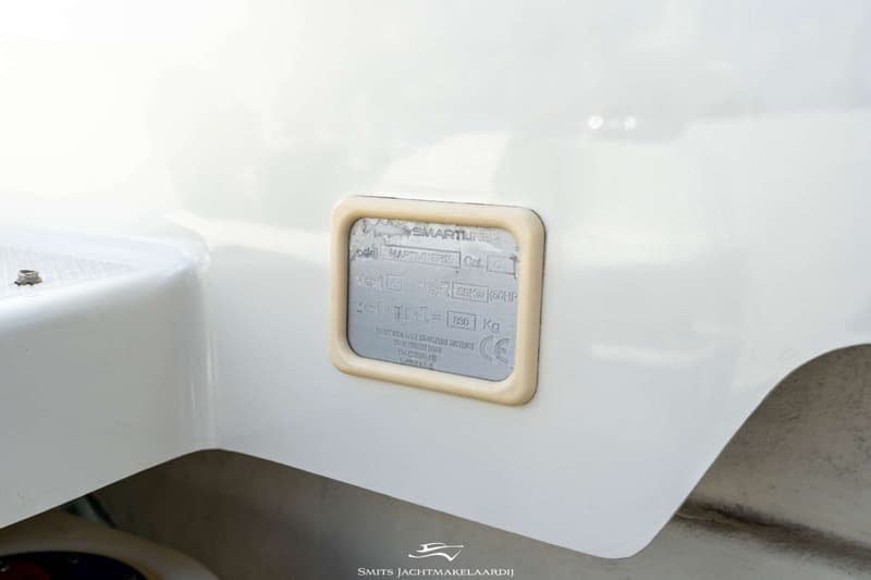 Een detailfoto van een wit bootonderdeel met een metalen plaatje met specificaties, waaronder "SMARTLINER" en "830 Kg".