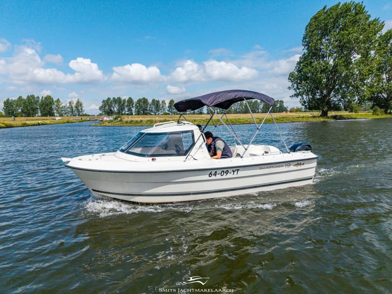 Een witte Smartliner 19 boot met registratienummer 64-09-YT vaart op een waterweg met een persoon aan het roer.