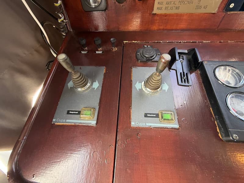Twee Cupa bedieningshendels voor boegschroef en hekschroef zijn zichtbaar op een houten paneel.