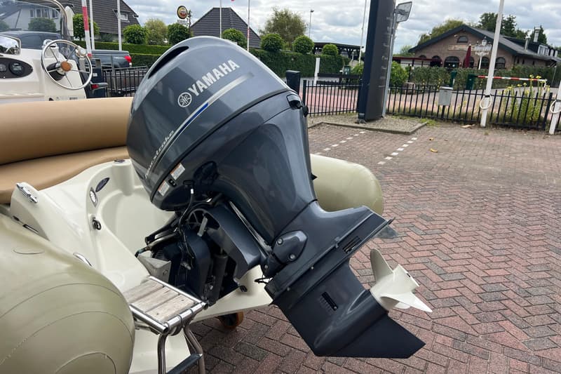 Een grijze Yamaha buitenboordmotor met een witte propeller is gemonteerd op een beige boot. — RIB Zodiac Medline 550