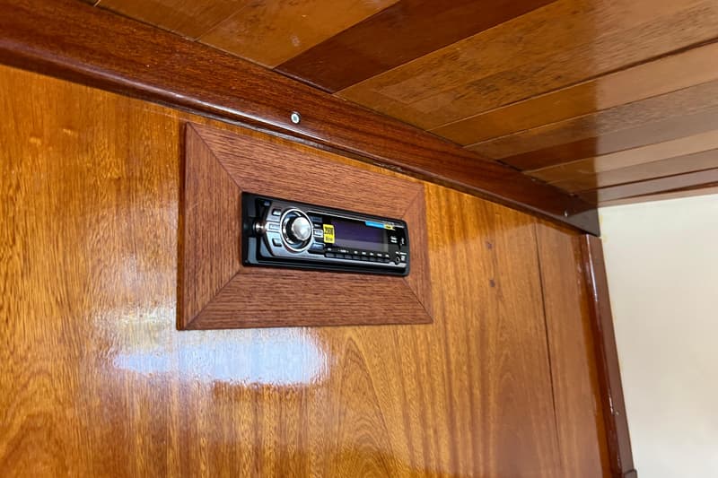 Een ingebouwde Sony autoradio met een zilveren draaiknop en een blauw display, omringd door een houten lijst.